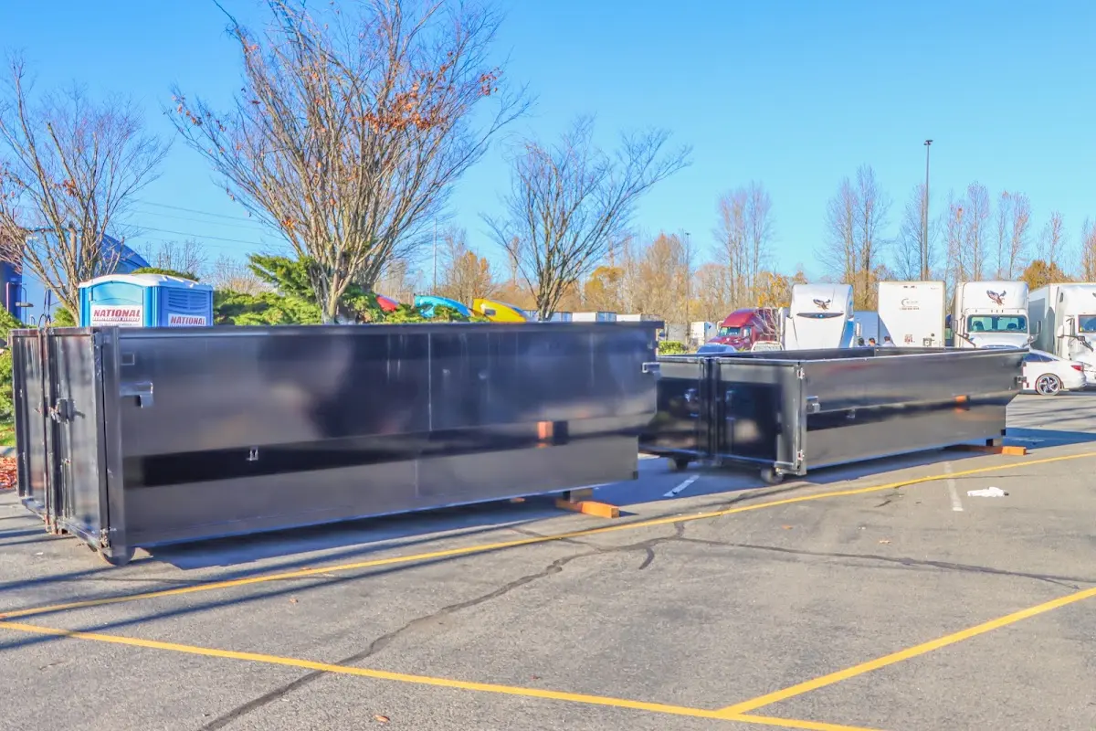 Professional dumpster rental service with roll-off container on residential driveway in Rathdrum